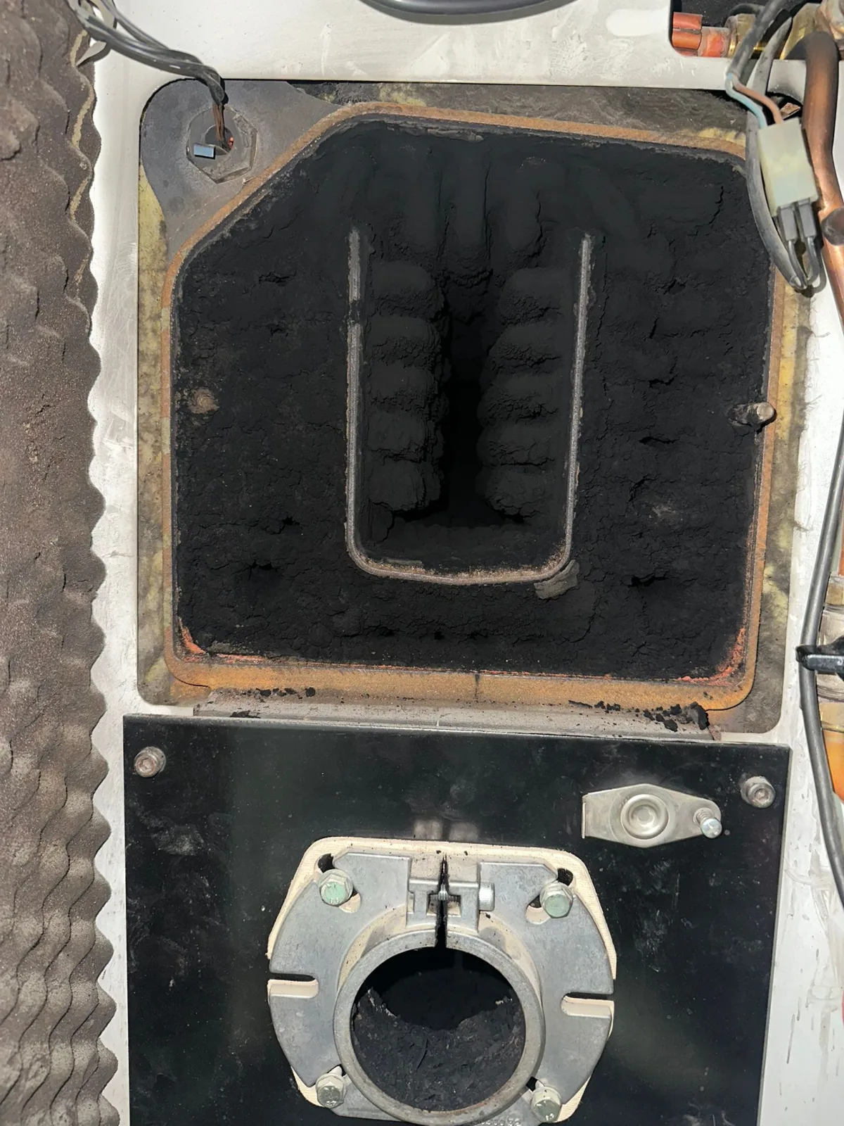 Intercambiador de caldera de gasoil cubierto de hollín antes de la limpieza